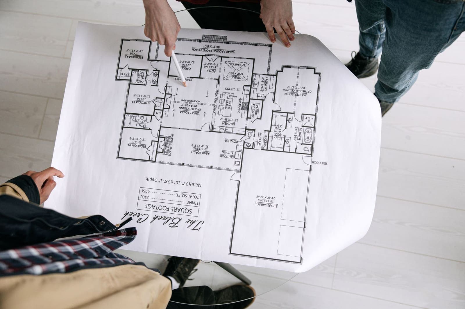 Person planning a home project on a desk with papers and a calendar spread out