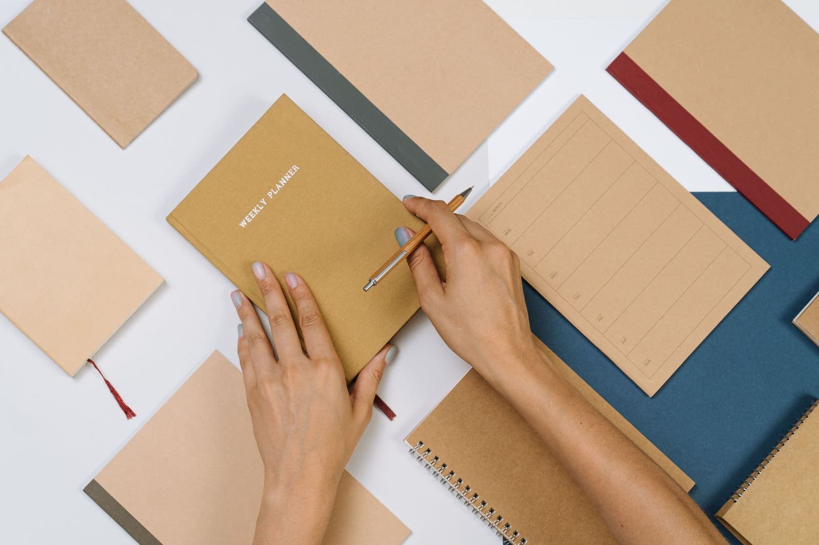 Open weekly planner notebook on a desk with a pen resting beside it