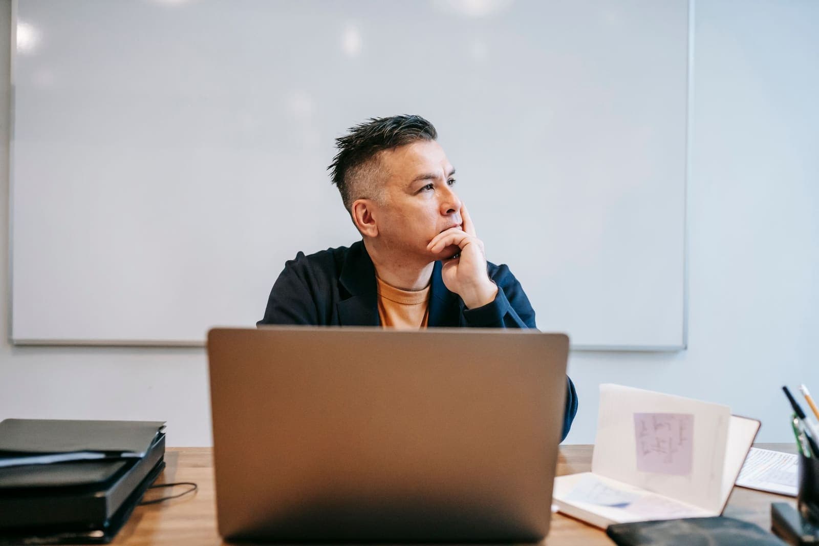 Person sitting at a laptop with a thoughtful expression, pausing before starting work