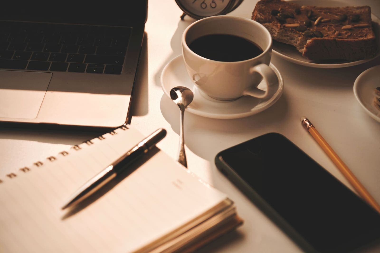 A tidy desk on a Sunday morning with a notebook, coffee cup, and soft natural light