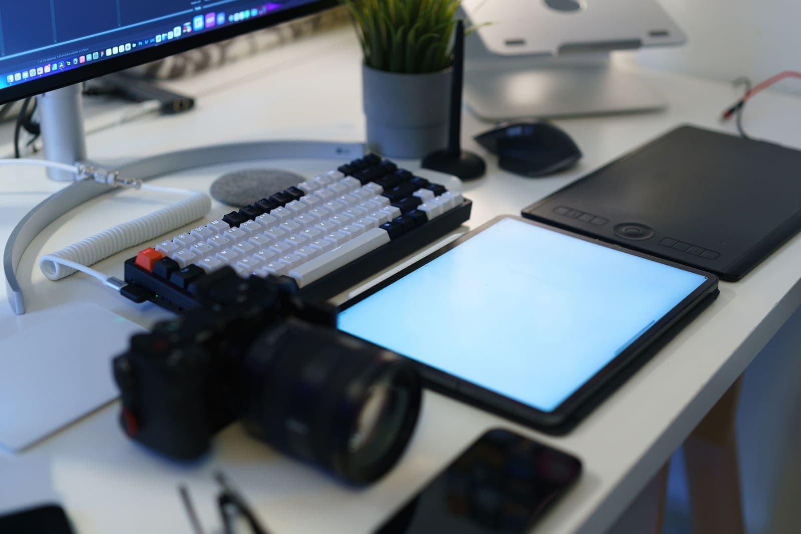Freelancer working at a home office desk with multiple screens and a coffee mug