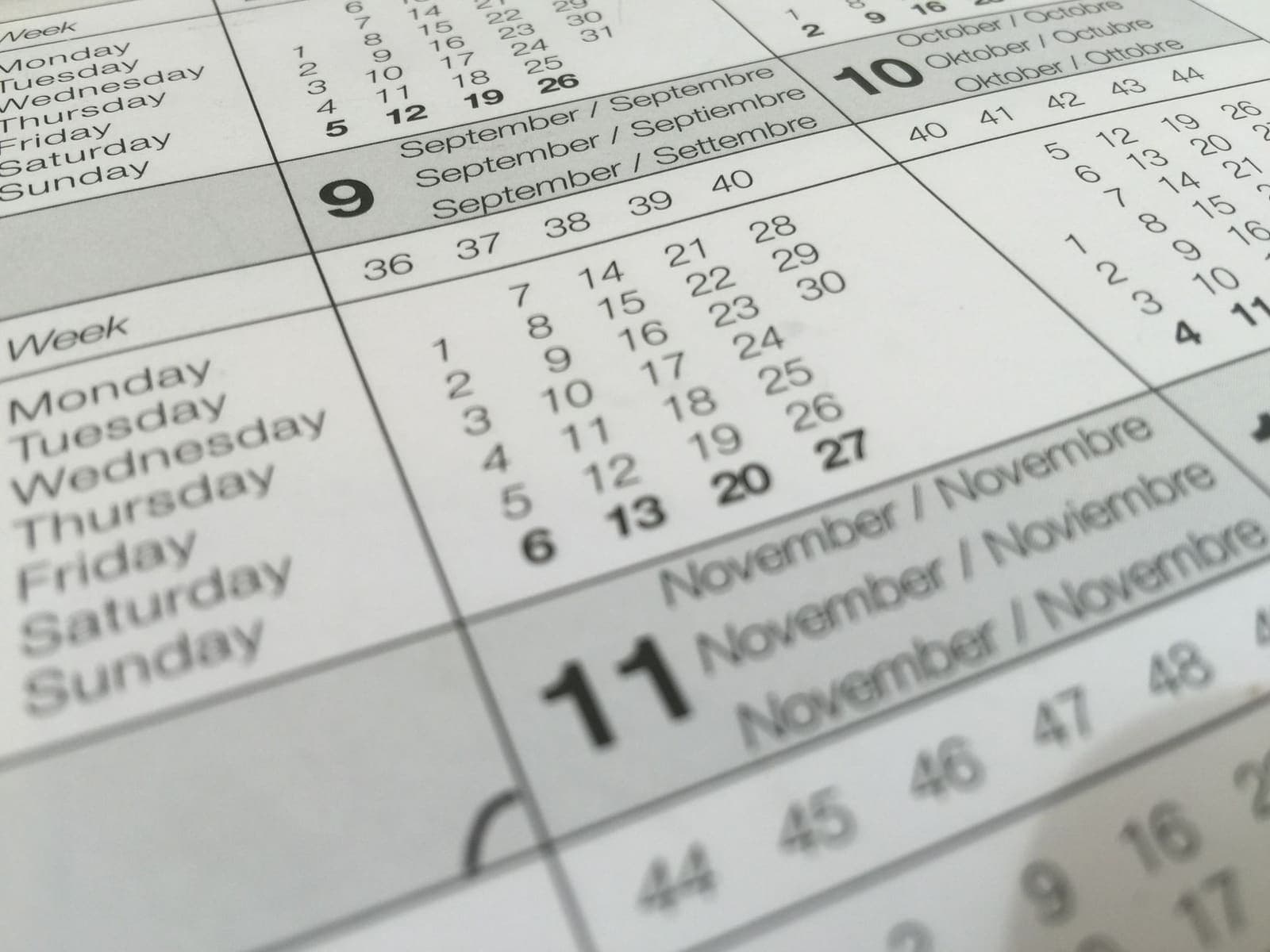 A desk calendar open to a weekly spread with a daily planner beside it